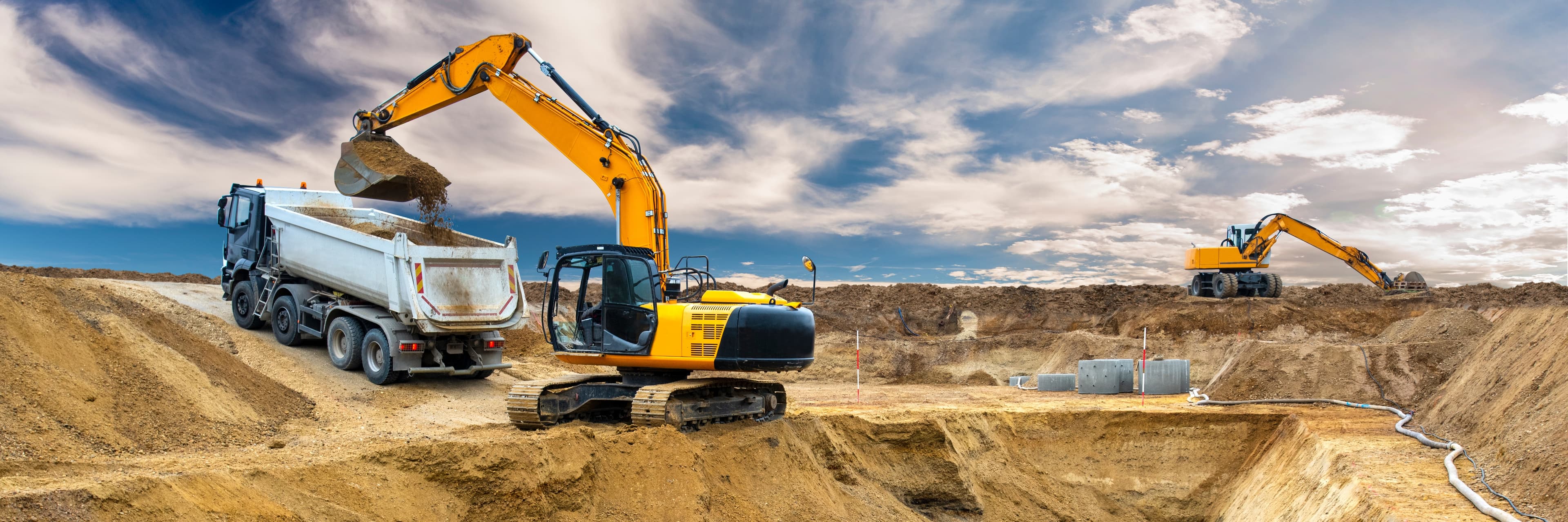 Bagger belädt einen Lkw auf einer Erdbaustelle